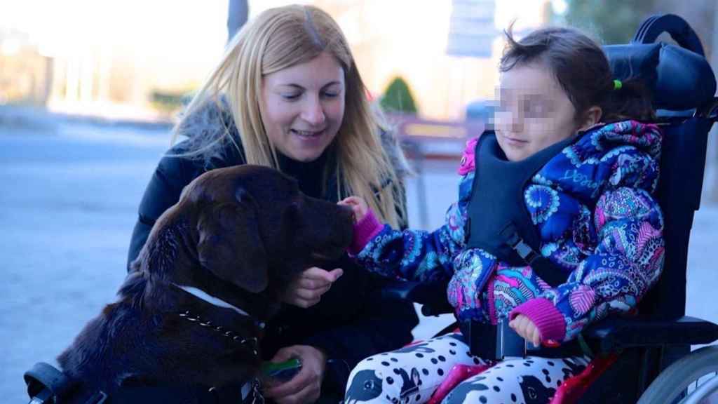 Una niña con una enfermedad rara juega con un perro de terapia. EP.