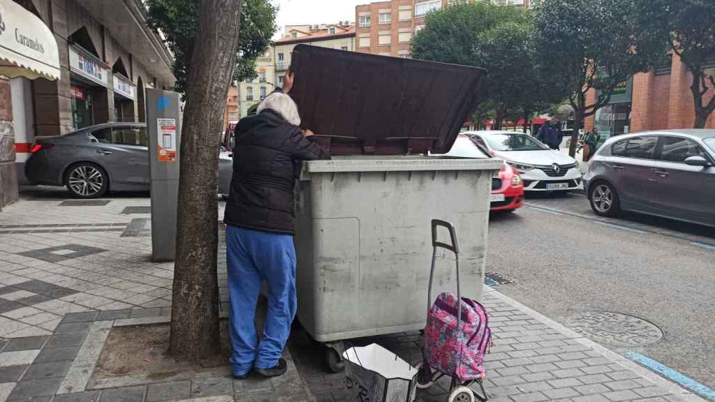 Una mujer busca comida en un contenedor en Valladolid.
