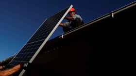 Dos técnicos instalan placas solares en una casa de Madrid.