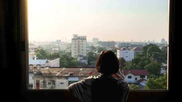 Imagen de archivo de una joven mirando por la ventana.