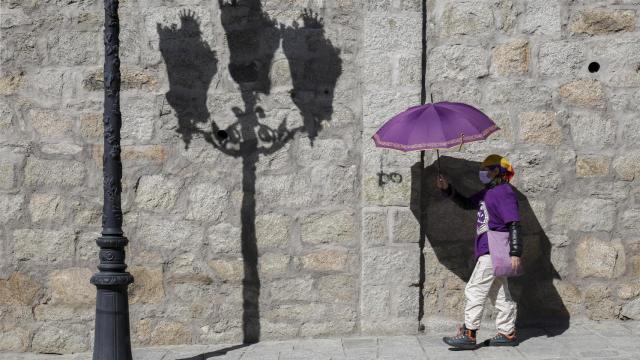 Una mujer vestida de morado se dirige a participar en una marcha