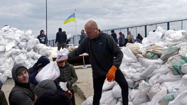Voluntarios llenan sacos de arena en Odesa para levantar barricadas.
