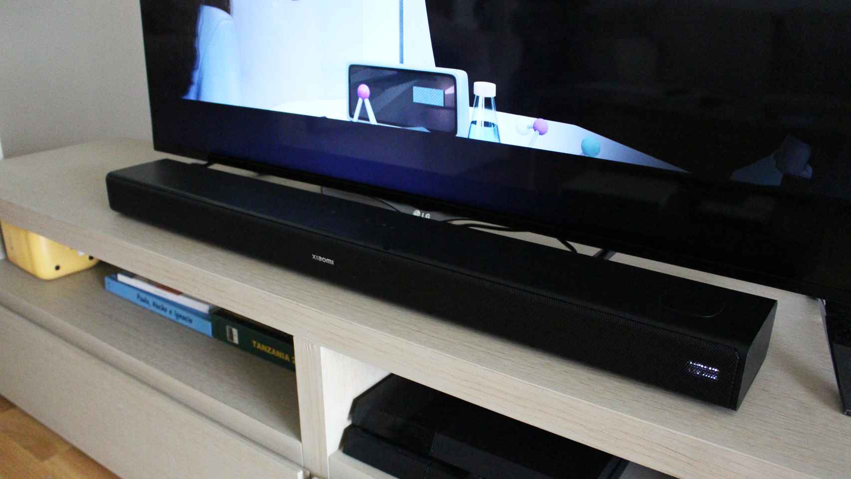 La Xiaomi Soundbar 3.1ch colocada justo entre las patas del televisor.