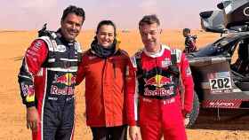 La mecánica Míriam Silva, comisaria técnica del Rally Dakar 2022, entre el ganador, Nasser Al-Attiyah (a la izquierda), y el subcampeón, Sébastien Loeb.