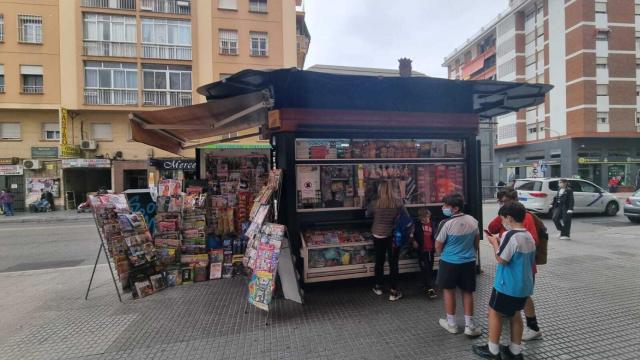 Varios niños esperan para comprar en un quiosco de Málaga capital.