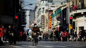 Un hombre pedalea en una calle céntrica de Pekín.
