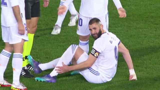 Karim Benzema, sentado sobre el césped se duele de su pierna izquierda