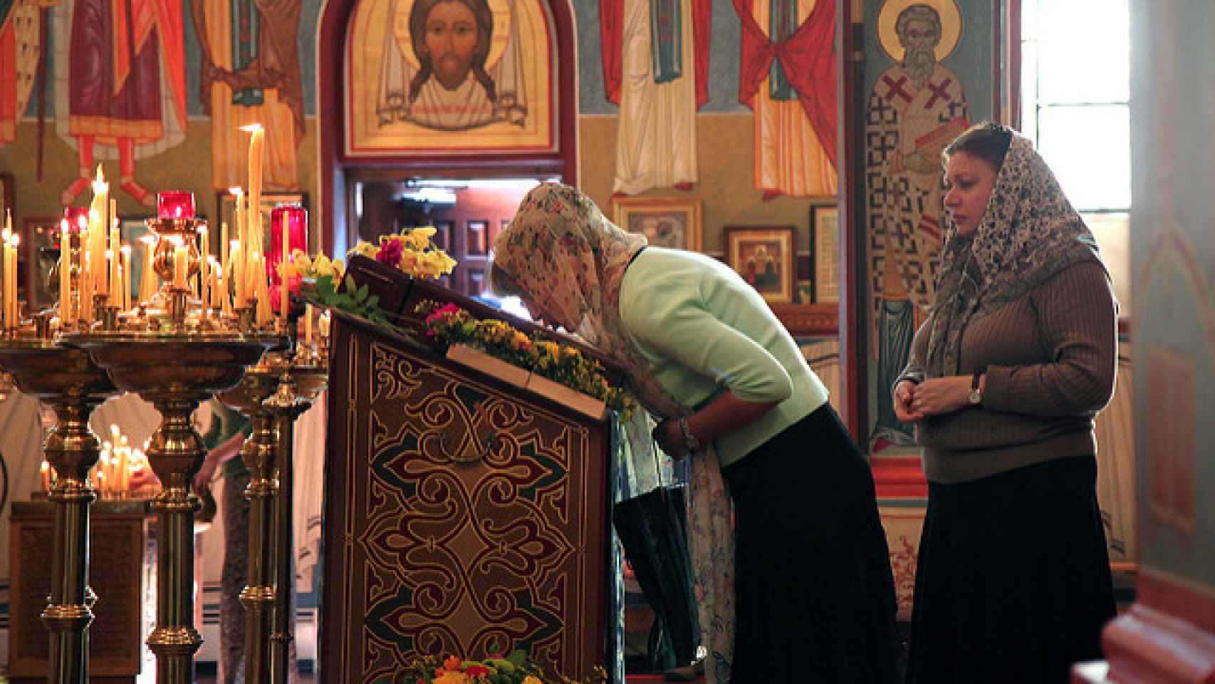 Imagen de una fiel besando el libro en una Iglesia ortodoxa.