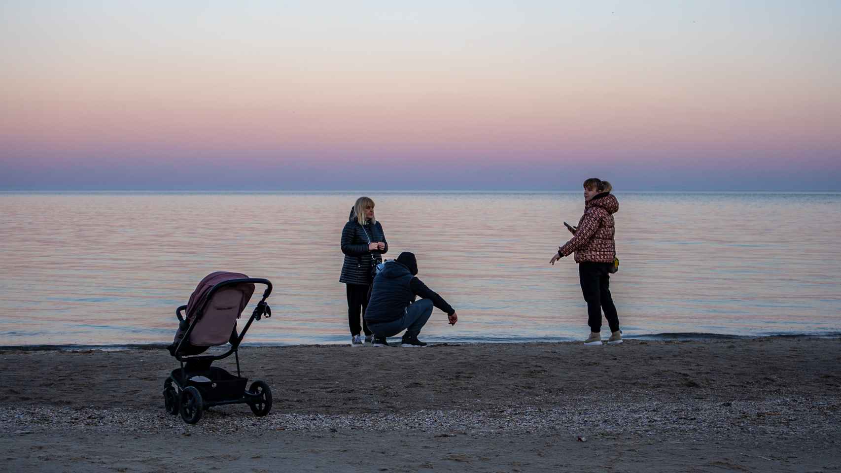 Un carrito de bebé y varias mujeres en Arkadia beach. / F.T.