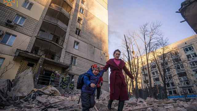 Una madre y su hijo abandonan su vivienda tras los bombardeos de las tropas rusas.