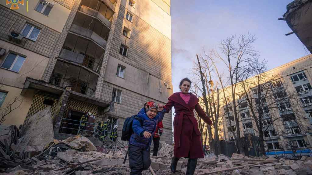 Una mujer y un niño en una zona residencial de las afueras de Kiev bombardeada por el Ejército ruso.