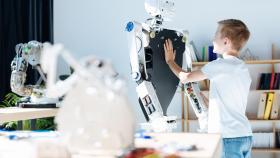 Imagen de archivo de un niño con un robot.