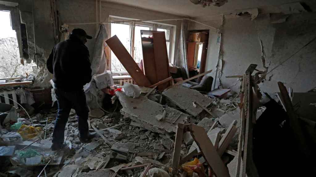 A resident walks into a damaged apartment in the besieged city of Mariupol.