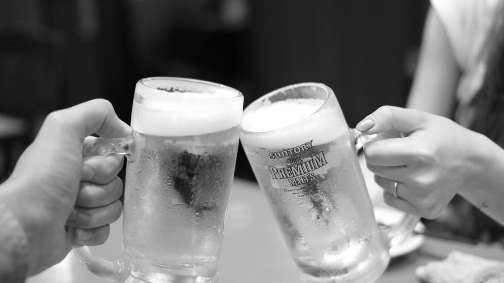 Dos clientes brindan con sus jarras de cerveza.
