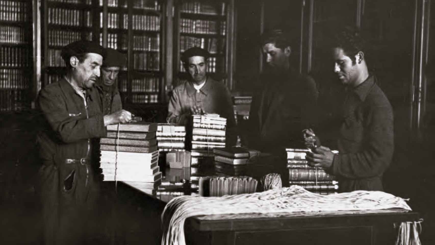 Hombres recogiendo libros en el Palacio Real durante la Guerra Civil.