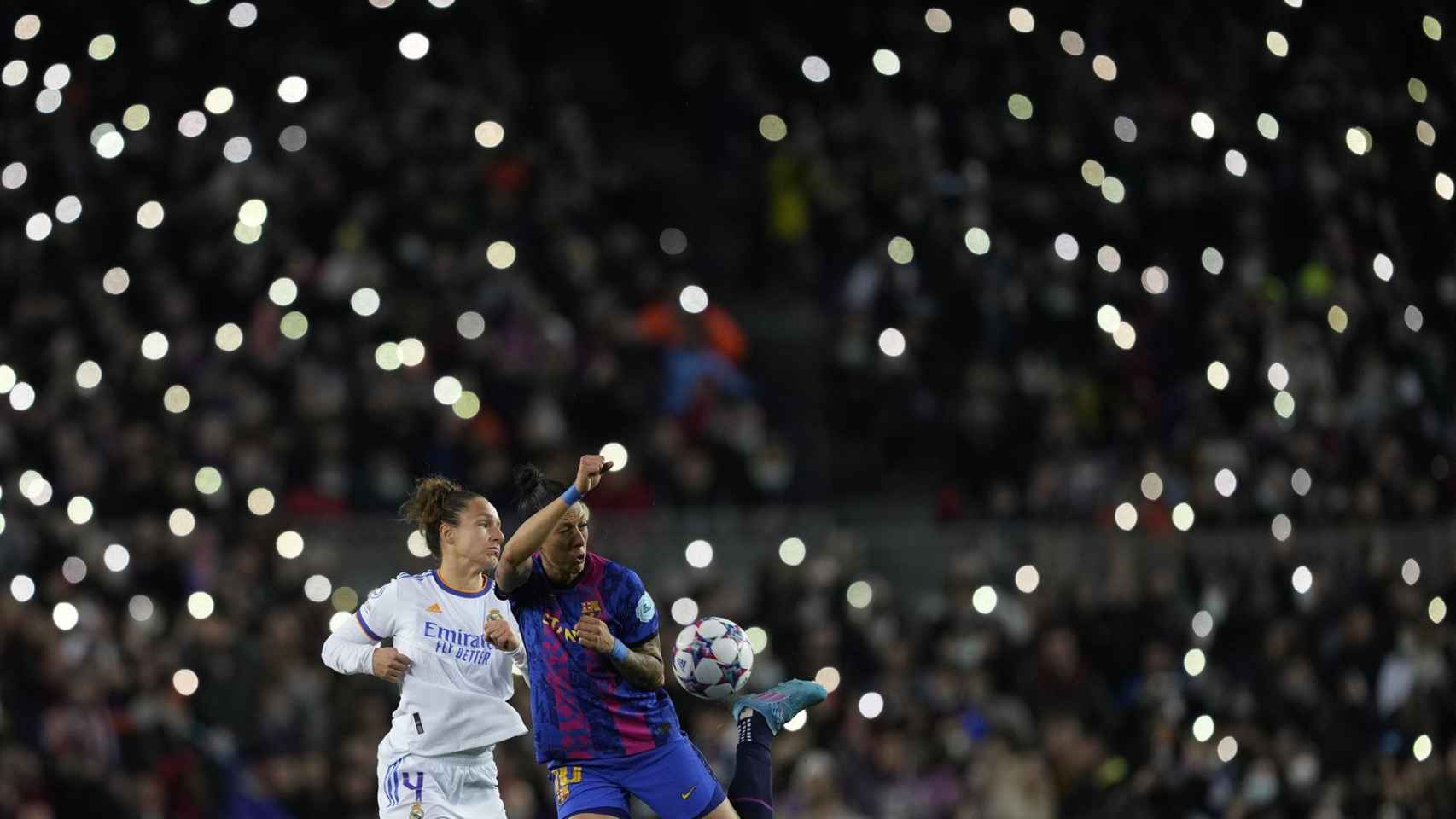 Jenni Hermoso, en acción con Babett Peter con un Camp Nou iluminado por los aficionados en El Clásico femenino