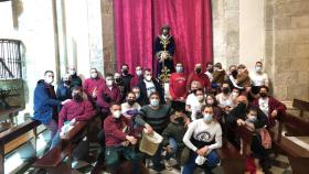 Miembros de la Hermandad Sentencia y Esperanza de Palencia junto a la talla de su Cristo de la Sentencia