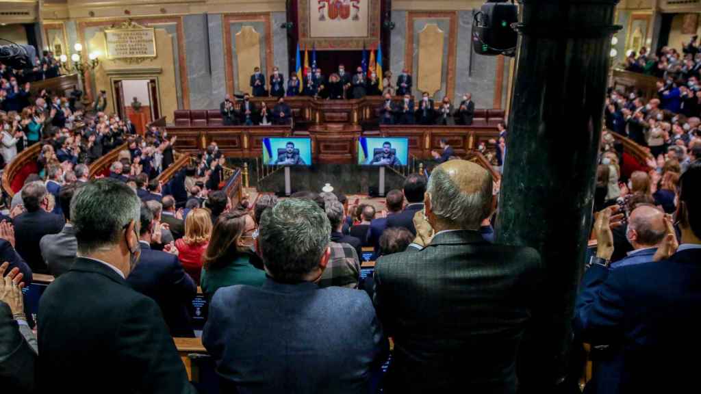 Asistentes aplauden tras la comparecencia telemática del presidente de Ucrania, Volodímir Zelenski, en el  Congreso de los Diputados,.