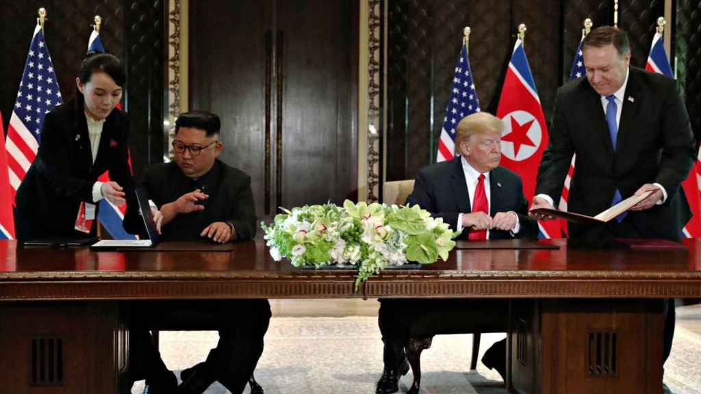 Kim Yo-jong entrega unos papeles a su hermano en la reunión con Trump en Singapur.