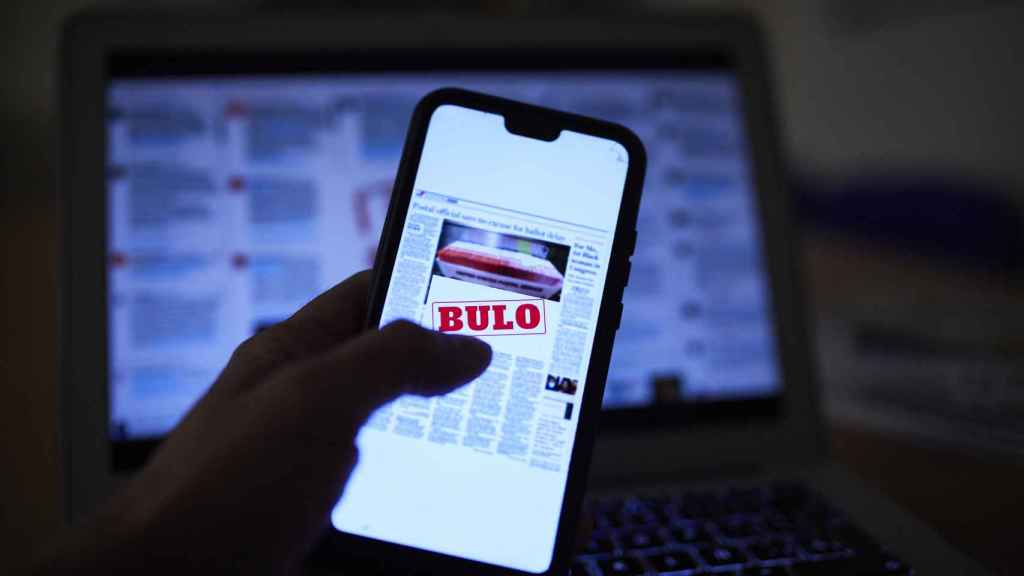 Una persona lee en su móvil una noticia falsa, en Madrid (España).