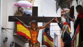 Aún bajo la intensa lluvia caída la Procesión de la Santa Cruz de Alicante sale entre las angostas calles del centro histórico de la ciudad.