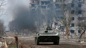 Miembros de las tropas prorrusas montan en un vehículo blindado durante los combates cerca de la planta de Azovstal en Mariupol