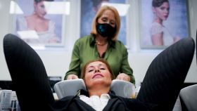 Imagen de una peluquería tras retirarse la obligatoriedad de las mascarillas en interior. La trabajadora, con mascarilla, y la clienta, sin ella.