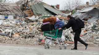 Un residente de Mariúpol abandona la ciudad con sus pertenencias en un carrito de la compra.