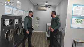 Dos agentes, en una de las lavanderías de autoservicio donde robó el detenido.