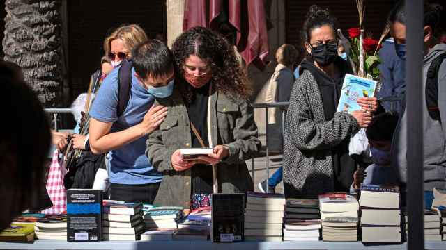 Varias personas miran un puesto de libros en la celebración de Sant Jordi de 2021 en Barcelona. Foto: David Zorrakino / Europa Press