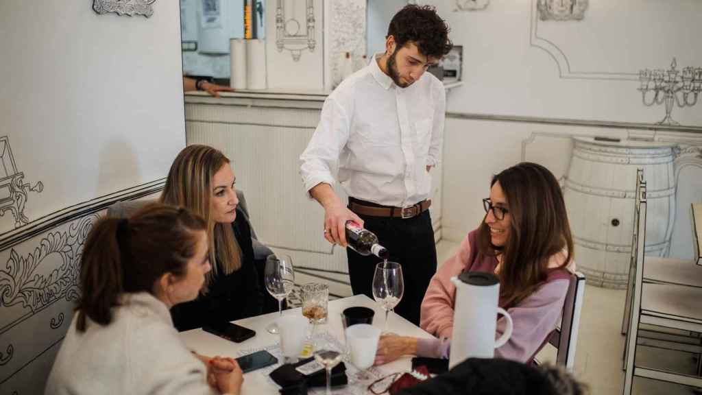 Un camarero sirve una bebida a un grupo de mujeres en un restaurante