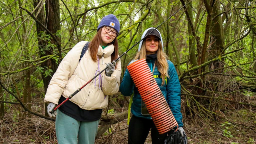 Dos voluntarias, una de las cuales posa con una caña de pescar