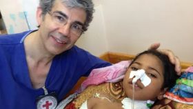 El cirujano británico David Nott y Aysha, una niña a la que salvó la vida en Gaza (Palestina) en 2014.