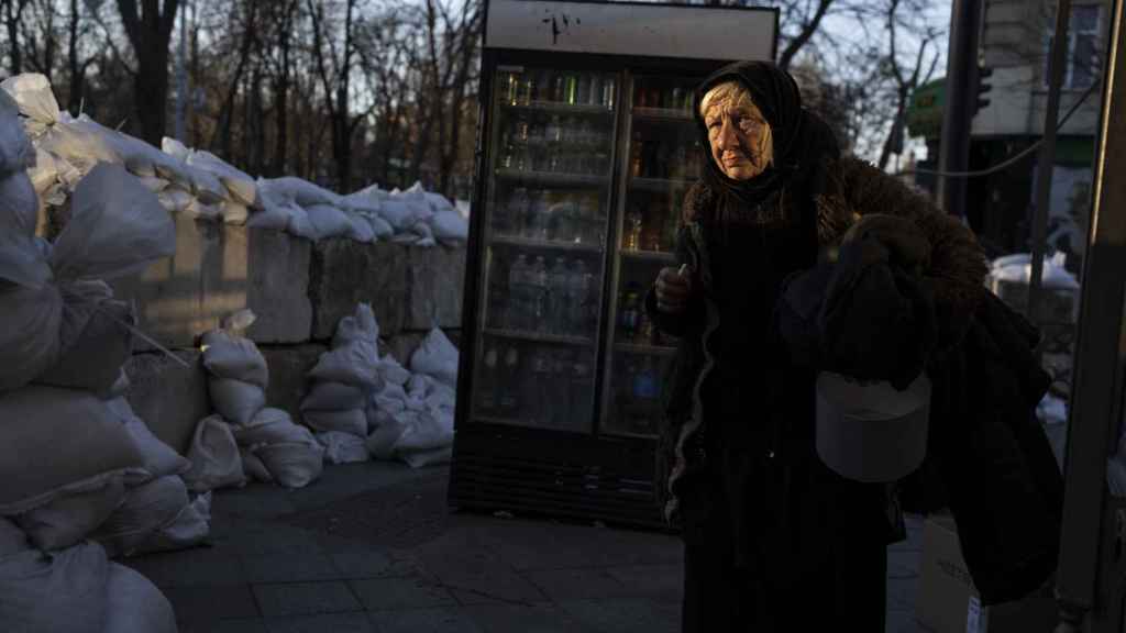 Una anciana pasa junto a bloques de hormigón cubiertos con sacos de arena en una calle de Odesa, en el sur de Ucrania.