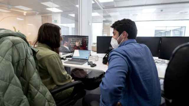 Dos empleados llevan mascarilla en el interior de una oficina. Europa Press