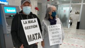Dos de los afectados, mostrando pancartas en el hall del propio hospital.