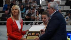 Una representante del comité olímpico ucraniano recoge la placa del evento.