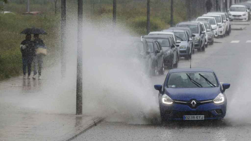 Un coche pasa salpicando agua tras intensas lluvias