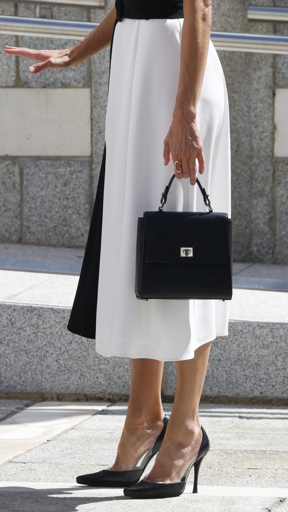 Como complementos, la Reina ha llevado un bolso de Hugo Boss y salones de Magrit.