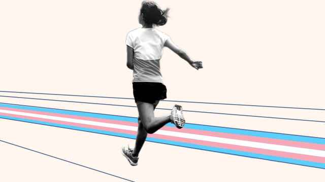 Una atleta en edad escolar corre sobre la bandera trans
