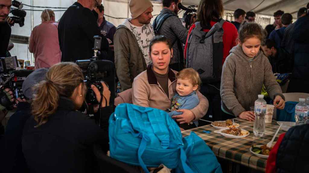 Una madre de la mano con su hija en el punto de llegada para los desplazados de las zonas invadidas por Rusia.