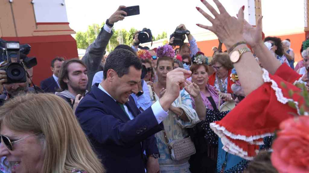 El presidente de la Junta, Juanma Moreno, baila sevillanas debajo de la portada de la feria de Sevilla.