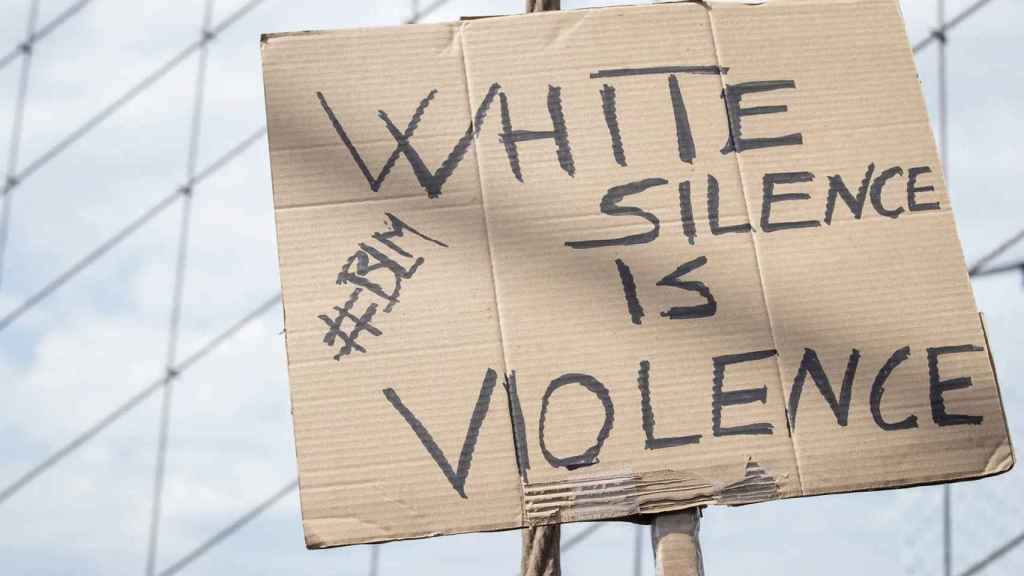 La pancarta de un activista de Black Lives Matter reza: El silencio blanco es violencia.