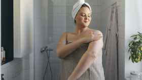 Una mujer se aplica su crema al salir de la ducha.