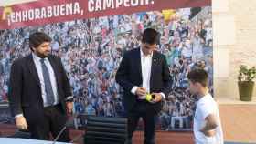 El presidente de Murcia, Fernando López Miras, este martes, en el Palacio de San Esteban, observando al tenista Carlos Alcaraz firmando un autógrafo a Álvaro, un niño de 8 años que vive en El Palmar.