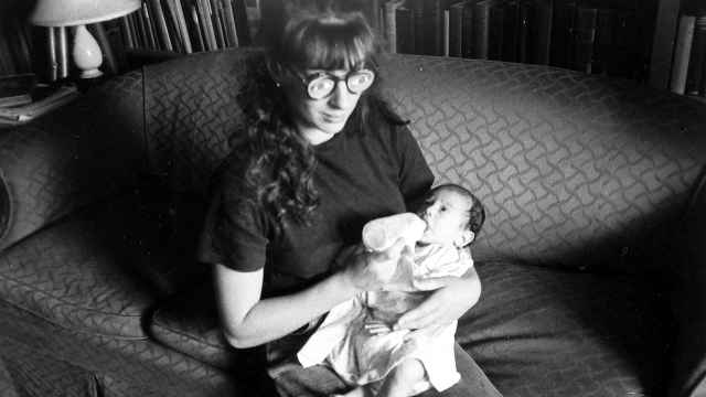 Robert Frank: 'Mary lleva unas gafas falsas mientras  da el biberón a Pablo en el sofá', h. 1951. © Andrea Frank Foundation