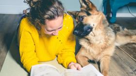 Imagen de una chica junto a su perro, un pastor alemán.