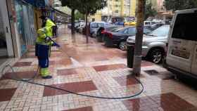 Una trabajadora de Limasam limpia una calle de Málaga de barro.