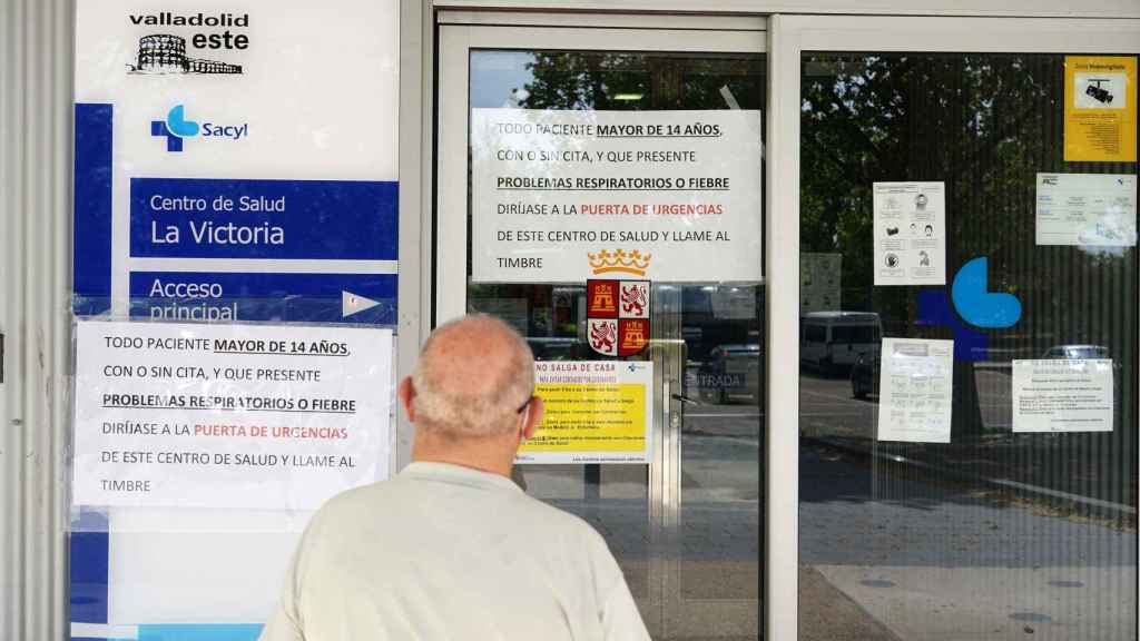 Un señor mira los carteles indicativos en la entrada del centro de salud del barrio de La Victoria