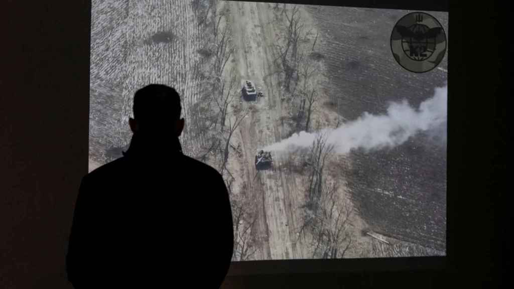 Un hombre ve un vídeo de un dron de un ataque a un tanque ruso en una exhibición de la actual invasión rusa de Ucrania, en el Museo Nacional de Historia de Ucrania en la Segunda Guerra Mundial, en Kiev.